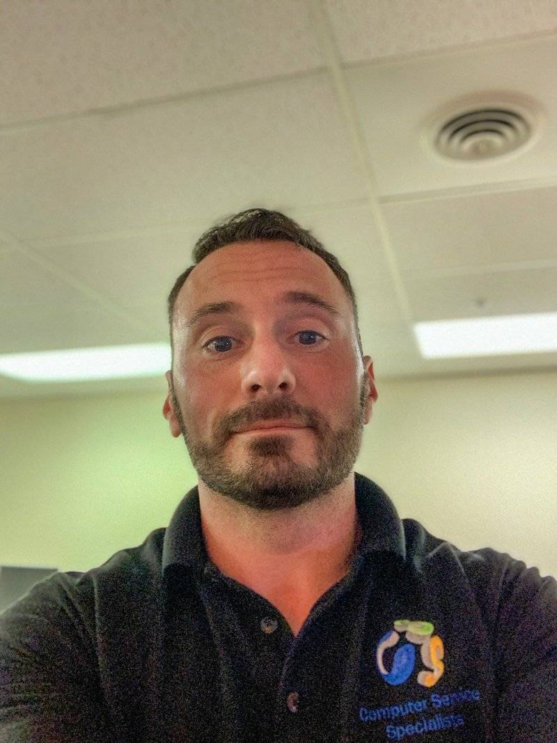Michael P. Goodman wearing a black Computer Service Specialists polo shirt with the company logo